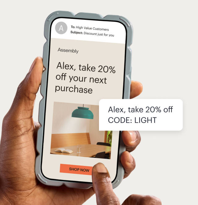 A phone displaying an email a business using Mailchimp, promoting a personalized 20% off discount. A floating text bubble shows the same promotion sent as an SMS message, including an automatically generated promo code.