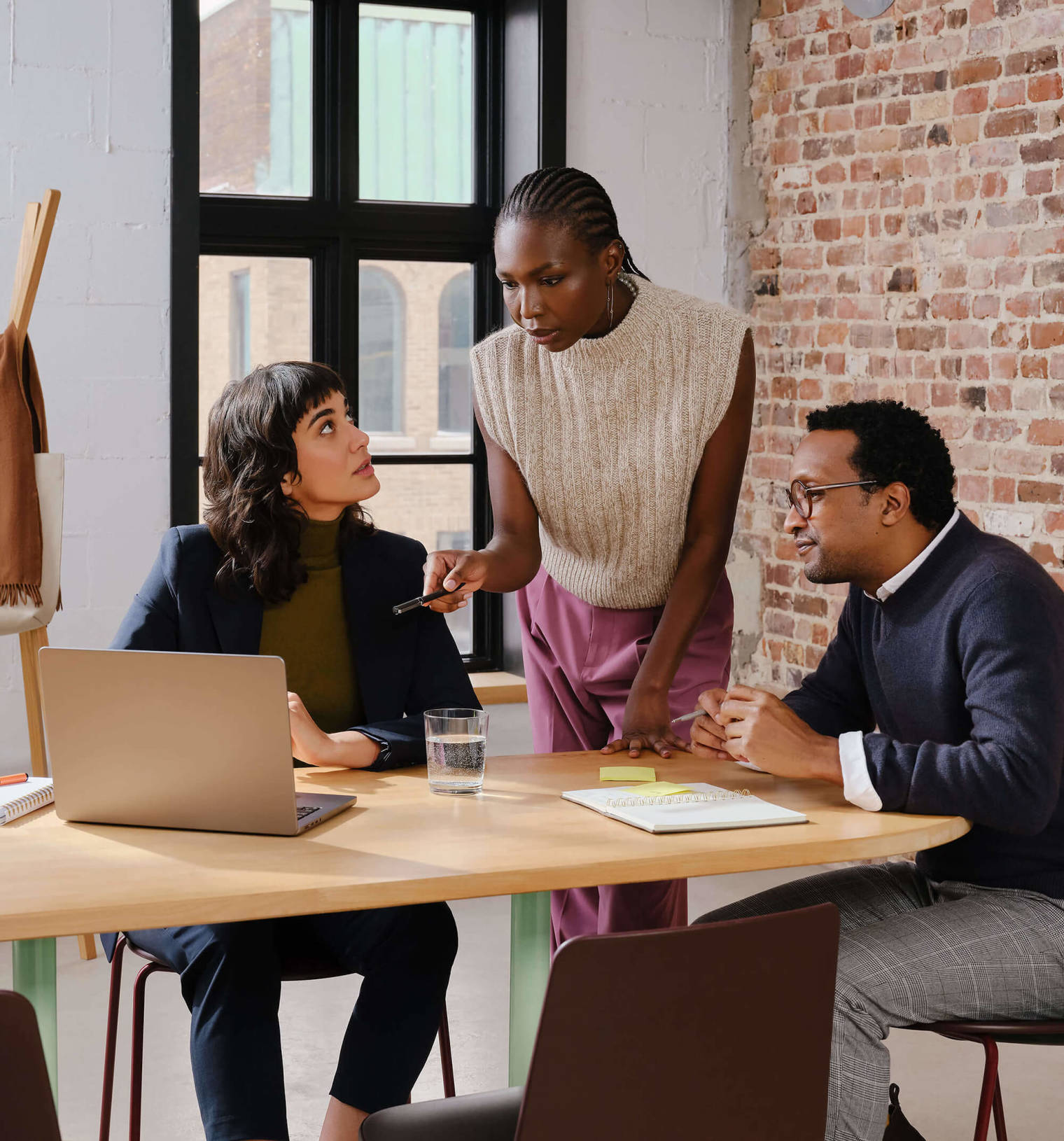 Three agency colleagues working together in a modern office while looking at their computer screen.