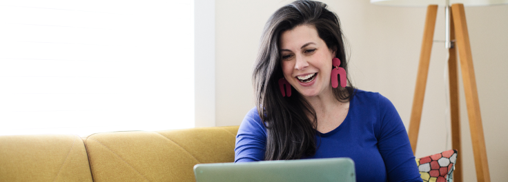 Smiling woman on her laptop at home