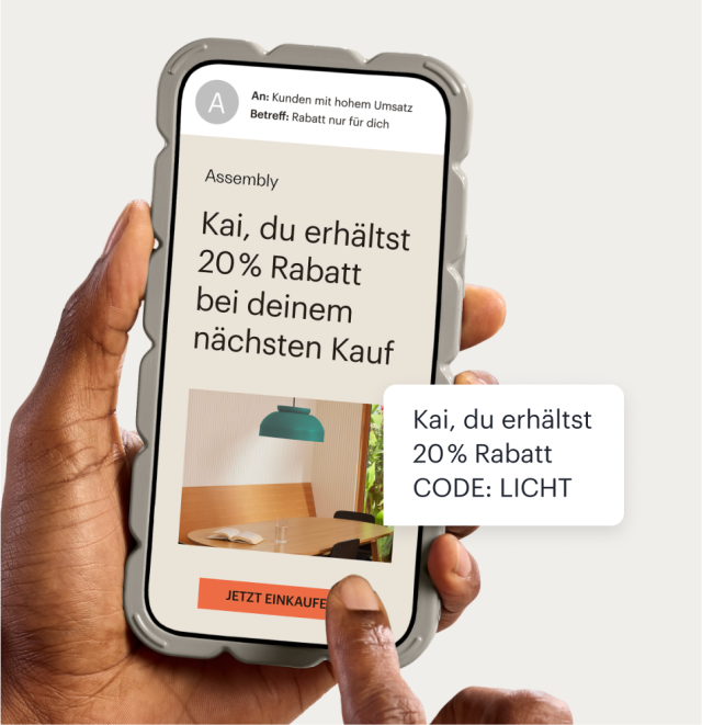 Ein Telefon, auf dem eine E-Mail an ein Unternehmen mit Mailchimp angezeigt wird, in der ein personalisierter Rabatt von 20 % beworben wird. Eine schwebende Textblase zeigt die gleiche Aktion, die als SMS-Nachricht gesendet wurde, einschließlich eines automatisch generierten Aktionscodes.