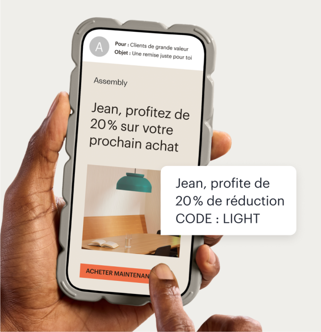 Un téléphone affichant un e-mail adressé à une entreprise utilisant Mailchimp, faisant la promotion d'une réduction personnalisée de 20 %. Une bulle de texte flottante affiche la même promotion envoyée sous forme de message SMS, y compris un code promotionnel généré automatiquement.