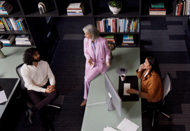 A group of people sitting at a desk speaking to their Customer Success manager.